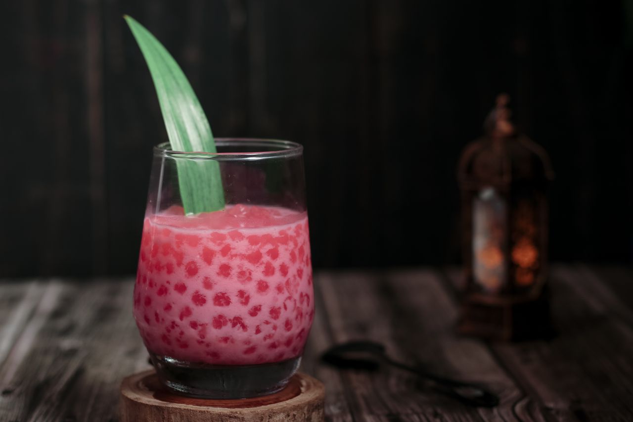 Close-up of a traditional Indonesian dessert, Bubur Mutiara, in a glass with pandan leaf in Jakarta.