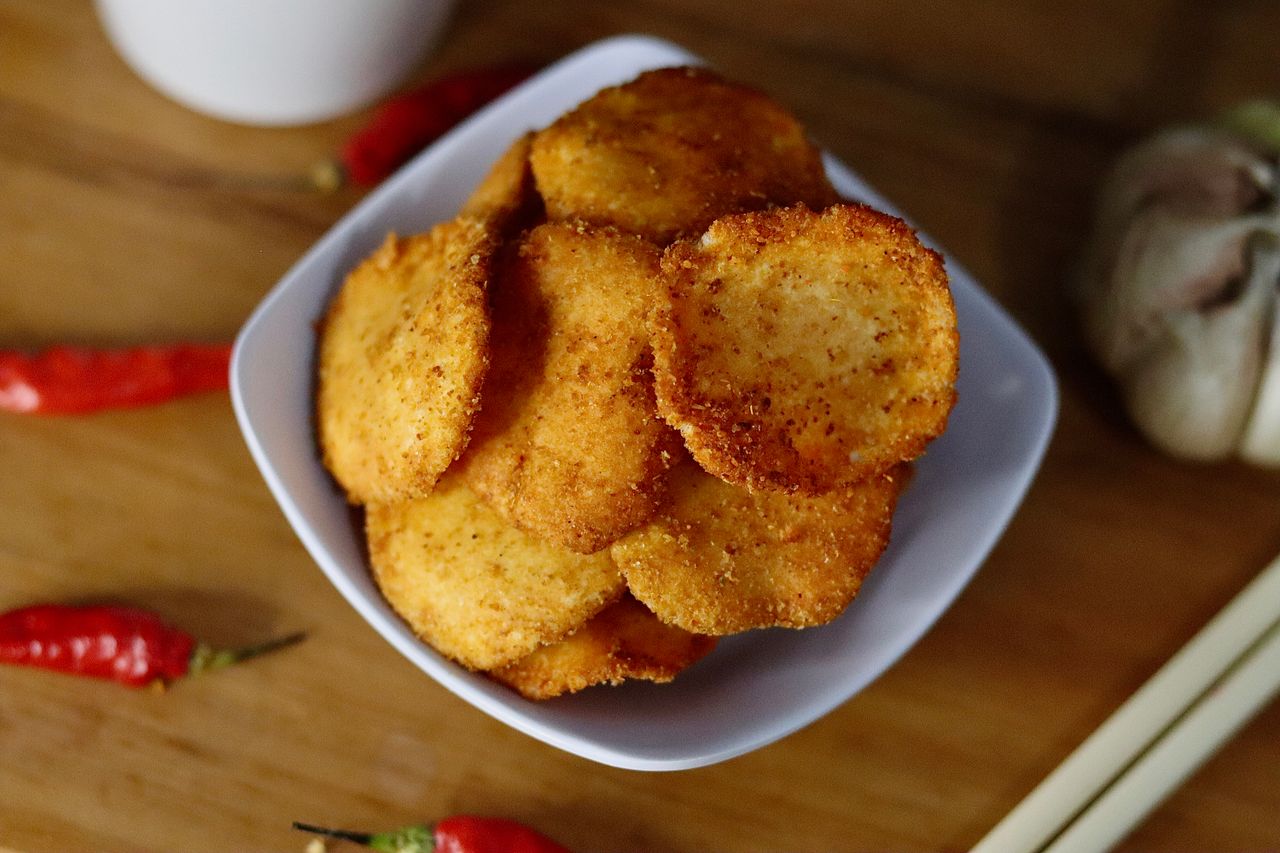 Mastering the First Impression: Your intriguing post title goes here Deliciously crisp Indonesian fried snack served in a white bowl, garnished with chilies and garlic.